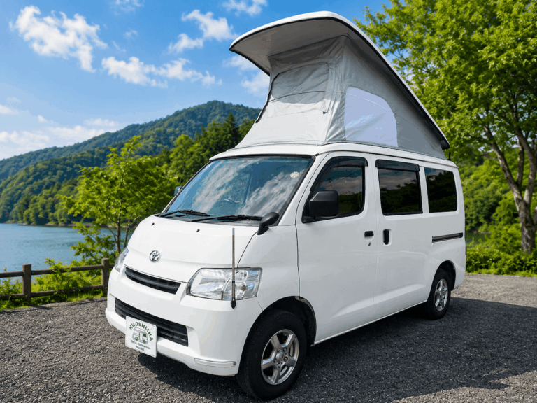 Compact Campervan, a Toyota TownAce conversion, with its pop-up roof open beside a lake in Hiroshima